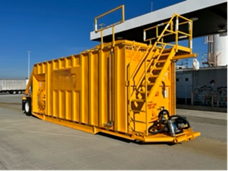 Dynamic Specialty Services 10,000-gallon stainless steel deicer storage tank with integrated pump system parked at airfield operations center.