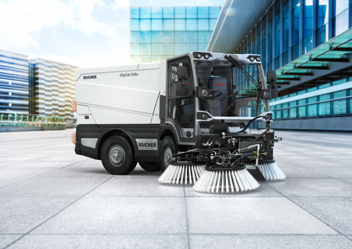 Bucher CityCat V20e electric compact sweeper parked outside a modern terminal.